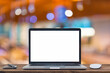 © RAYBON - Desk Laptop with blank screen on table of coffee shop blur background