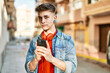 © Krakenimages.com - Young caucasian guy smiling using smartphone at the city