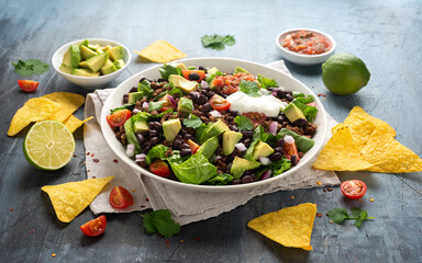 Wall Mural - Beef Taco salad with romaine lettuce, avocado, tomato salsa, black bean and tortilla chips. Mexican healthy food