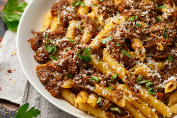 Pasta alla Genovese on a white bowl with parmesan cheese. Traditional neapolitan food.