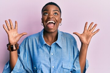 Wall Mural - Young african american woman wearing casual clothes celebrating crazy and amazed for success with arms raised and open eyes screaming excited. winner concept