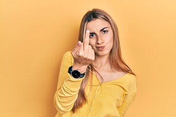 Canvas Print - Beautiful hispanic woman wearing casual yellow sweater showing middle finger, impolite and rude fuck off expression