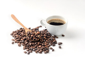 wooden spoon on coffee beans and a cup of black coffe on whtie background