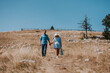 © Dinno - Loving couple holding hands while going down the mountain on a sunny day. Man and woman holding hands and happily going down the mountain while enjoying their moment.