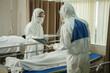 © iammotos - group of asian doctor wearing  ppe suit is currently examining the infection and treating patients coughing  from coronavirus or covid 19 on bed in quarantine room at hospital . flu outbreak