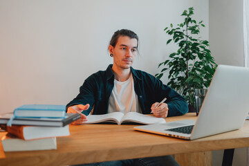 College student at campus while studying virtual learning for pass exam to university. Young man study using laptop in home