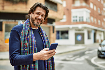 middle age handsome man using smartphone at the town