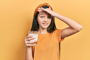 Sticker - Young brunette girl drinking a glass of milk stressed and frustrated with hand on head, surprised and angry face