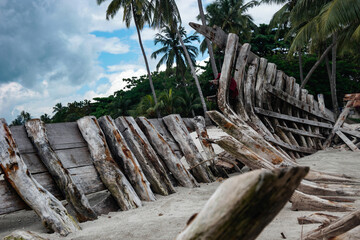 wrecked wooden boat covered by beach sand