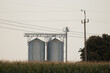 Corn field with silos in the background