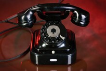 Old Black Telephone On Red Background