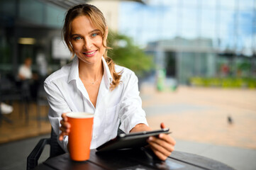 Young businesswoman on a coffee break, smiling at camera