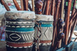 Traditional leather African drums with patterns, and wooden knobkerries.