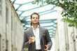 © Acronym - A young successful businessman is walking down the street. Man in a casual wear. Business, freelance and remote work.