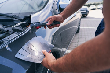 Poster - Person using shades cards of grey for choosing car colour