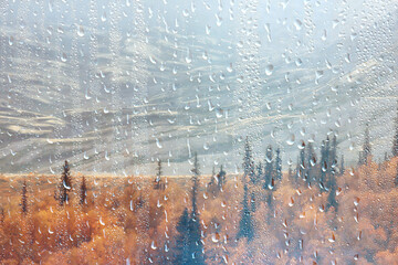 rain window view, water drops on glass view forest and mountains landscape background