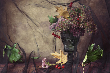 Wall Mural - autumn bouquet with dry oak leaves, pink flowers with red berries on rustic background covered with 
