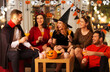 friendship, holiday and people concept - group of happy smiling friends in halloween costumes of vampire, devil, witch and cheetah with non-alcoholic drinks at home party at night