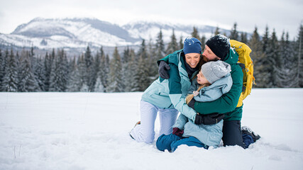 Wall Mural - Family with small daughter hugging outdoors in winter nature, Tatra mountains Slovakia.