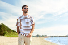 Summer Holidays And People Concept - Portrait Of Young Man In Sunglasses Walking Along Beach In Tallinn, Estonia