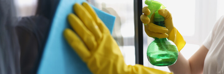 Wall Mural - Female hands in yellow gloves wash windows with rag and cleaning agent