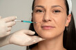 © vladimirfloyd - Portrait of a young satisfied woman on a face filler injection procedure