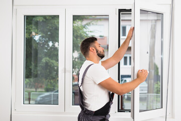 worker fixing pvc windows indoor