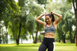 © LIGHTFIELD STUDIOS - happy athletic woman in crop top adjusting ponytail in green park