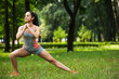 © LIGHTFIELD STUDIOS - full length of cheerful sportswoman doing squat exercise in park