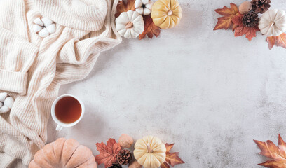 Wall Mural - autumn composition. a cup of coffee, cotton flowers, autumn leaves and sweater on stone background. 