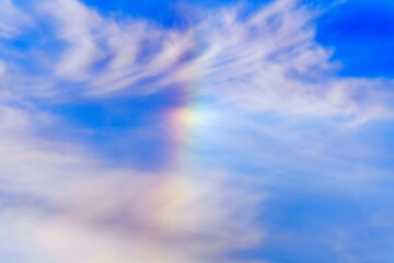 Wall Mural - Rainbow on the background of a blue sky with clouds, in winter