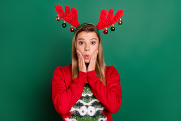 Portrait of attractive amazed girl wearing red deer ears wow reaction sale christmastime isolated over green color background