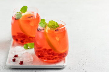 Wall Mural - Iced tea, pomegranate citrus drink in glasses. Space for text.