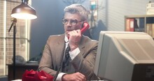 Portrait Shot Of The Of The Attractive Man Office Worker In Suit Speaking On The Mobile Phone And Explaining Something Of Working Process While Looking Away