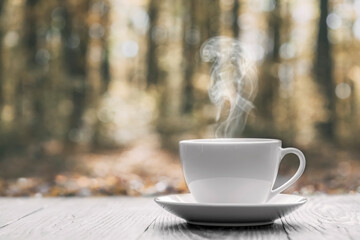 Wall Mural - hot coffee on the table on a autumn background