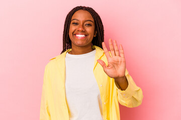 Young african american woman isolated on pink background  smiling cheerful showing number five with fingers.