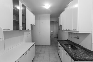 Wall Mural - Greyscale view of the kitchen in the apartment, with shelves, sink