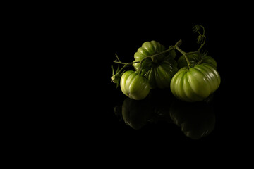 green homemade beautiful tomatoes on a black background