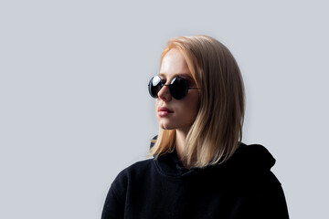 Poster - blonde in black and round sunglasses on a white background