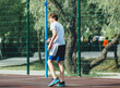 © Natali - Cute teenager plays basketball at city playground. A boy holds basketball ball in his hands outside. Active life, hobby, sports for children