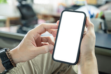 Wall Mural - cropped shot of man hand holding blank white screen smartphone while sitting at office.