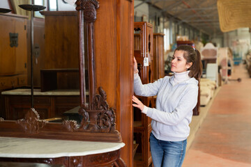 Wall Mural - Positive woman shopping in furnishings store choosing new furniture for apartment