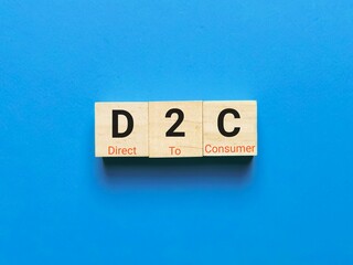 Business and finance concept. Alphabets D2C on wooden cubes against blue background.