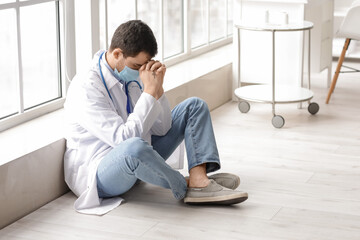 Religious doctor praying in clinic