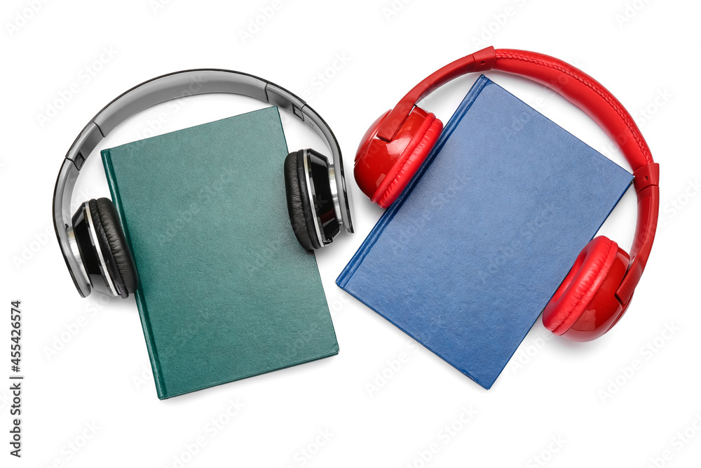 Modern headphones with books on white background