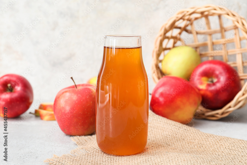 Bottle of apple juice on light background