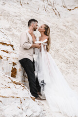 Wall Mural - Beautiful wedding couple bride and groom at wedding day outdoors at ocean beach. Happy marriage couple o