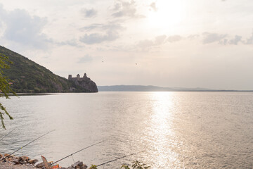 The Golubac Fortress,  medieval fortified town, Danube river at sunset. Sun reflection on the water.