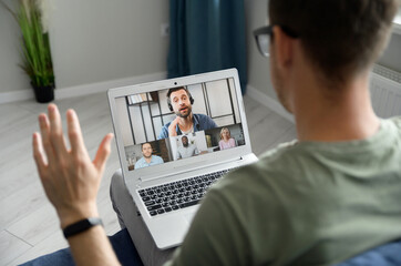 Wall Mural - Brainstorm, online video meeting, virtual conference with multi ethnic coworkers, employee, colleagues. View over shoulder of a guy on a screen with webcam shots of diverse people