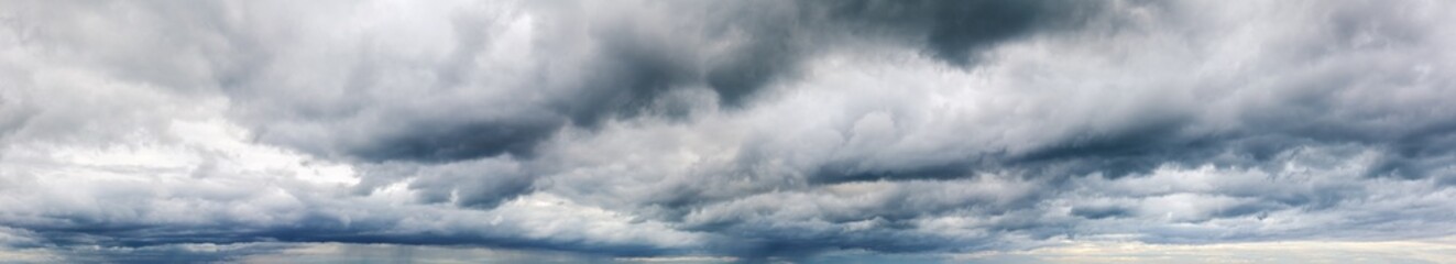 Stormy cloudy sky wide panorama, dramatic dark blue thunderclouds, gale cloudscape, gray cumulus rain clouds panoramic view, thunderstorm heaven landscape, overcast cloudiness weather, hurricane skies